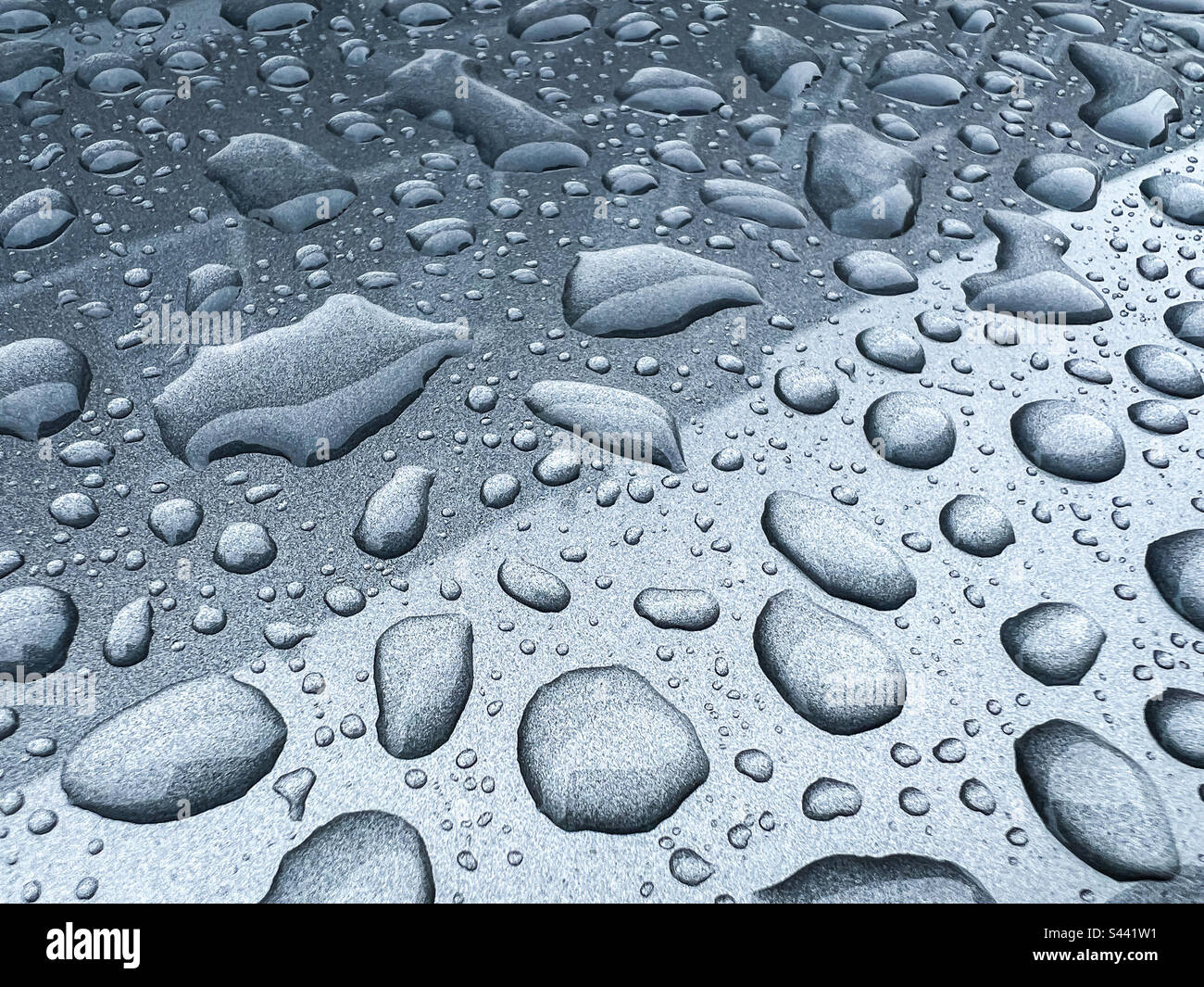 Regentropfen auf grauer Metalloberfläche Stockfoto
