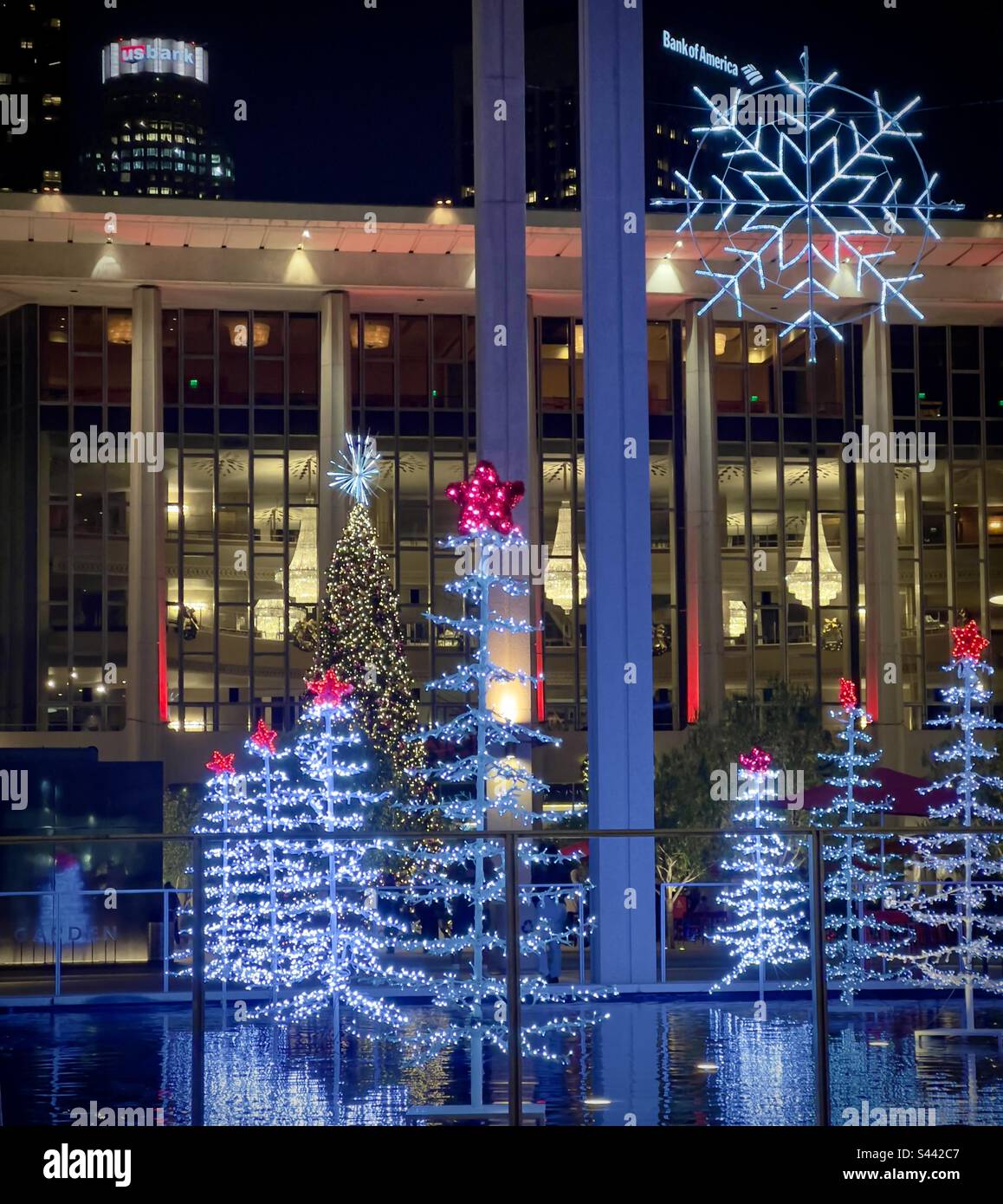 LOS ANGELES, Kalifornien, 2022. DEZEMBER: Weihnachtsbäume und Weihnachtsdekorationen werden nachts im Music Center in Downtown mit LEDs beleuchtet. Wolkenkratzer im Hintergrund sichtbar Stockfoto