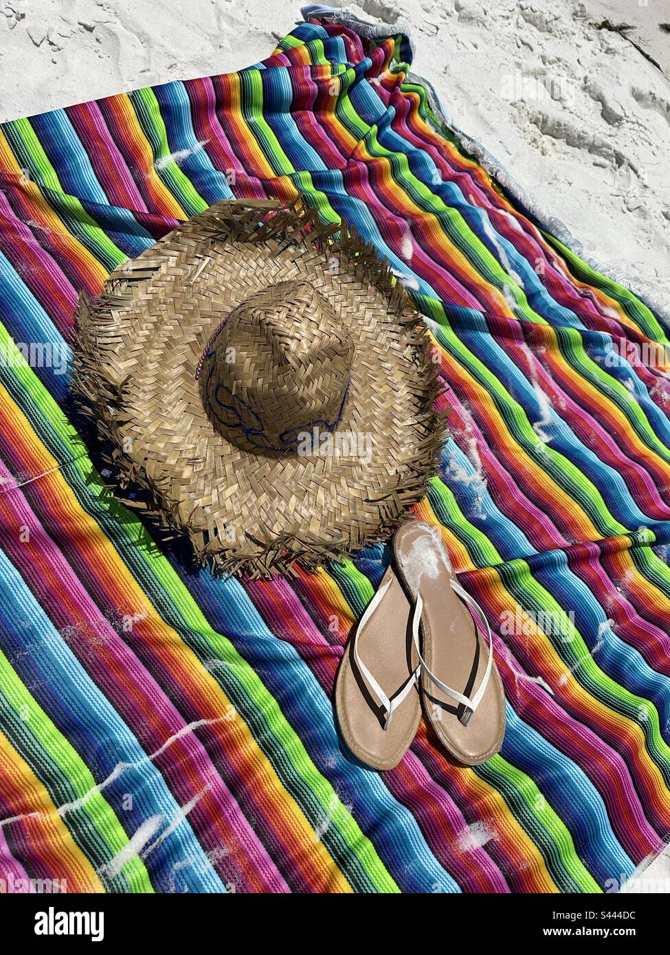Sombrero, farbenfroher Poncho und Sandalen am Strand Stockfoto