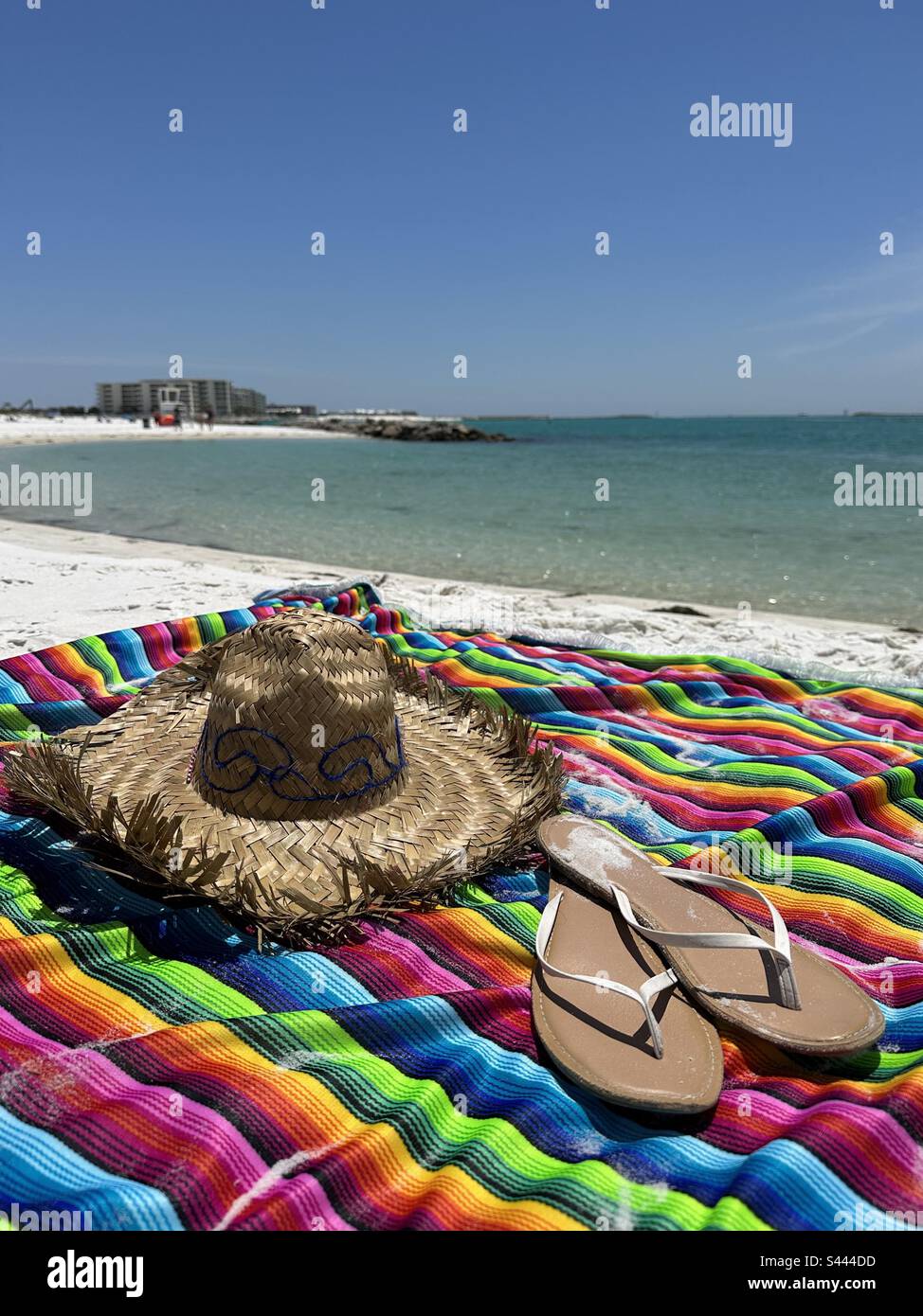 Sombrero, farbenfroher Poncho, Sandalen, mit Strandhintergrund Stockfoto