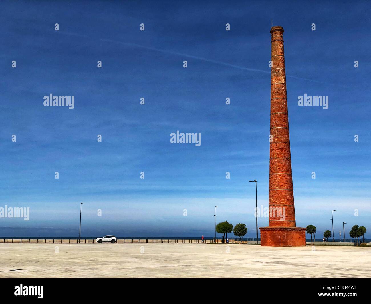 Der ehemalige Kamin der Konservenfabrik steht auf dem Stadtplatz in Espinho, Portugal, mit Blick auf den Atlantischen Ozean, 2023 - Smartphone-aufgenommenes Stockfoto