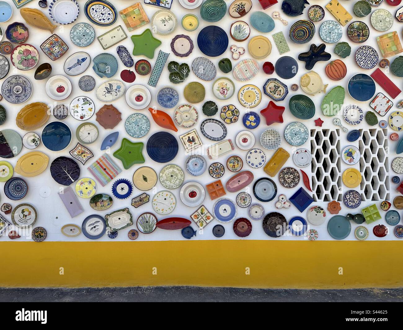 Teller und Töpferwaren hängen an der Wand eines Töpferladens an der Algarve, Portugal Stockfoto