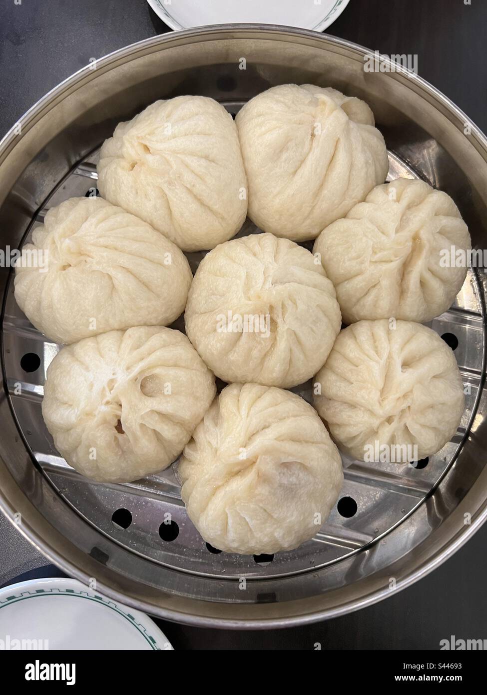 Acht asiatische Schweinebällchen in einem Dampfgarer aus Edelstahl, wo sie gerade gekocht haben, und jetzt servieren - Smartphone-aufgenommenes Stockfoto