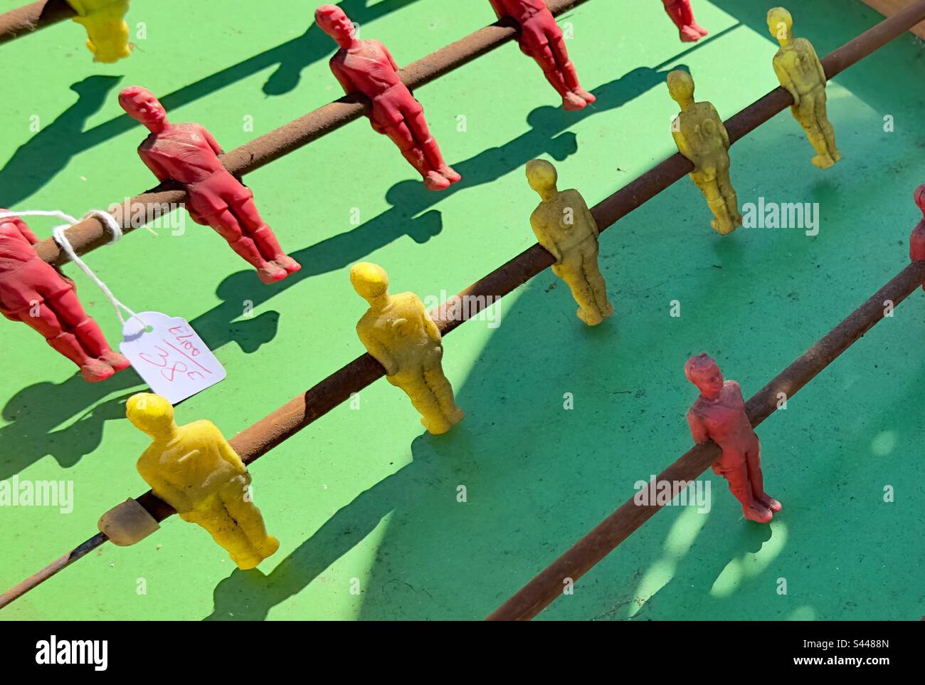 Ein traditionelles Tischfußballspiel mit grünem Stoff, das in einem französischen Flohmarkt zum Verkauf angeboten wird. Stockfoto