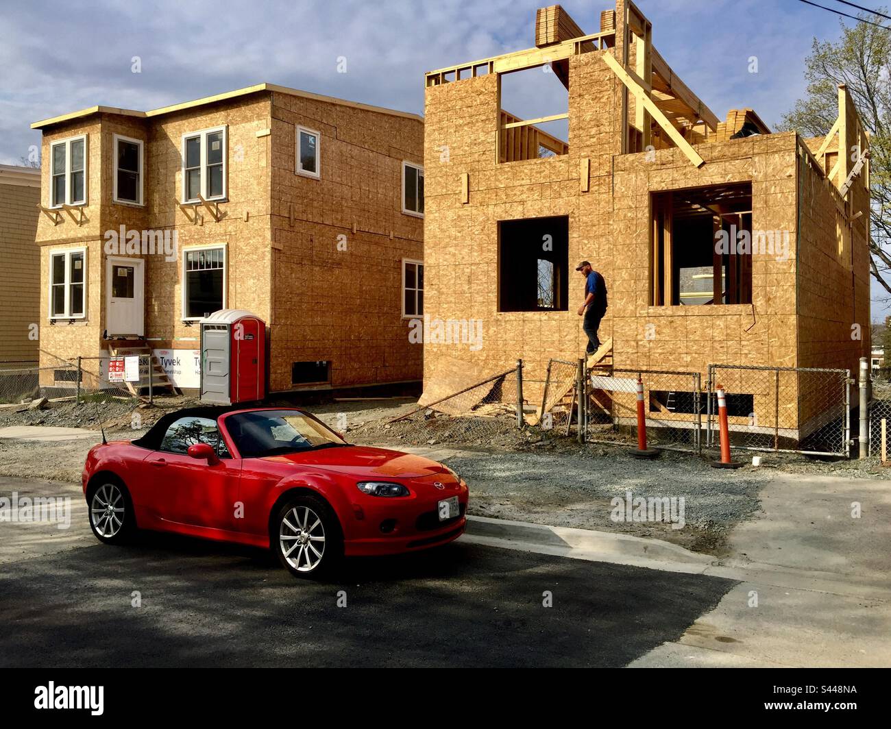 Erschwingliche Bauarbeiten, Halifax, Nova Scotia, Kanada. Ein Cabrio, ein spätes Modell, roter Sportwagen, der auf der Straße geparkt ist. Gehäuse. Versorgung. - Smartphone-aufgenommenes Stockfoto