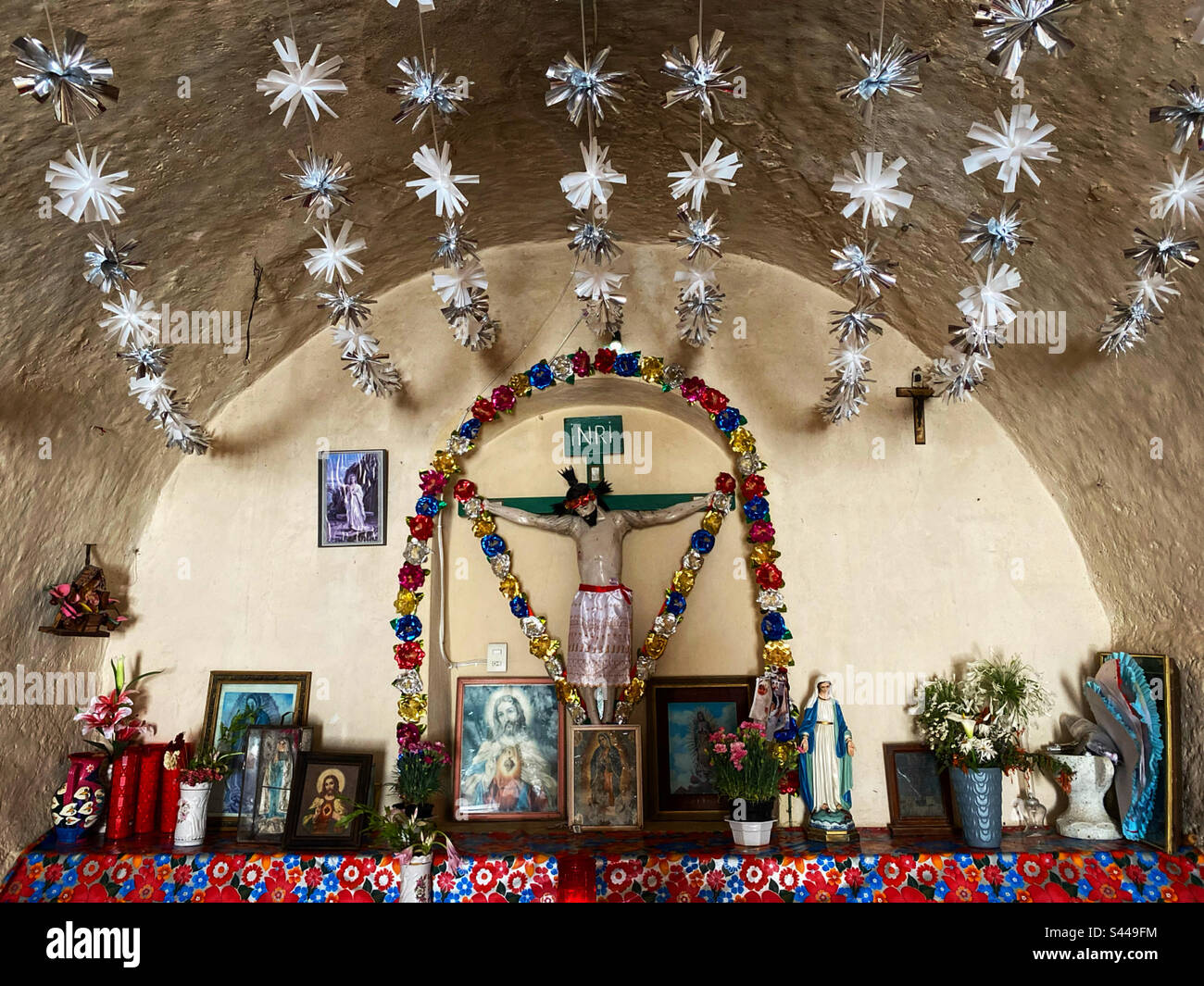 Heilige und ein Bild von Jesus Christus gekreuzigt schmücken eine Krone in San Antonio de la Cal, Queretaro, Mexiko - Smartphone-aufgenommenes Stockfoto