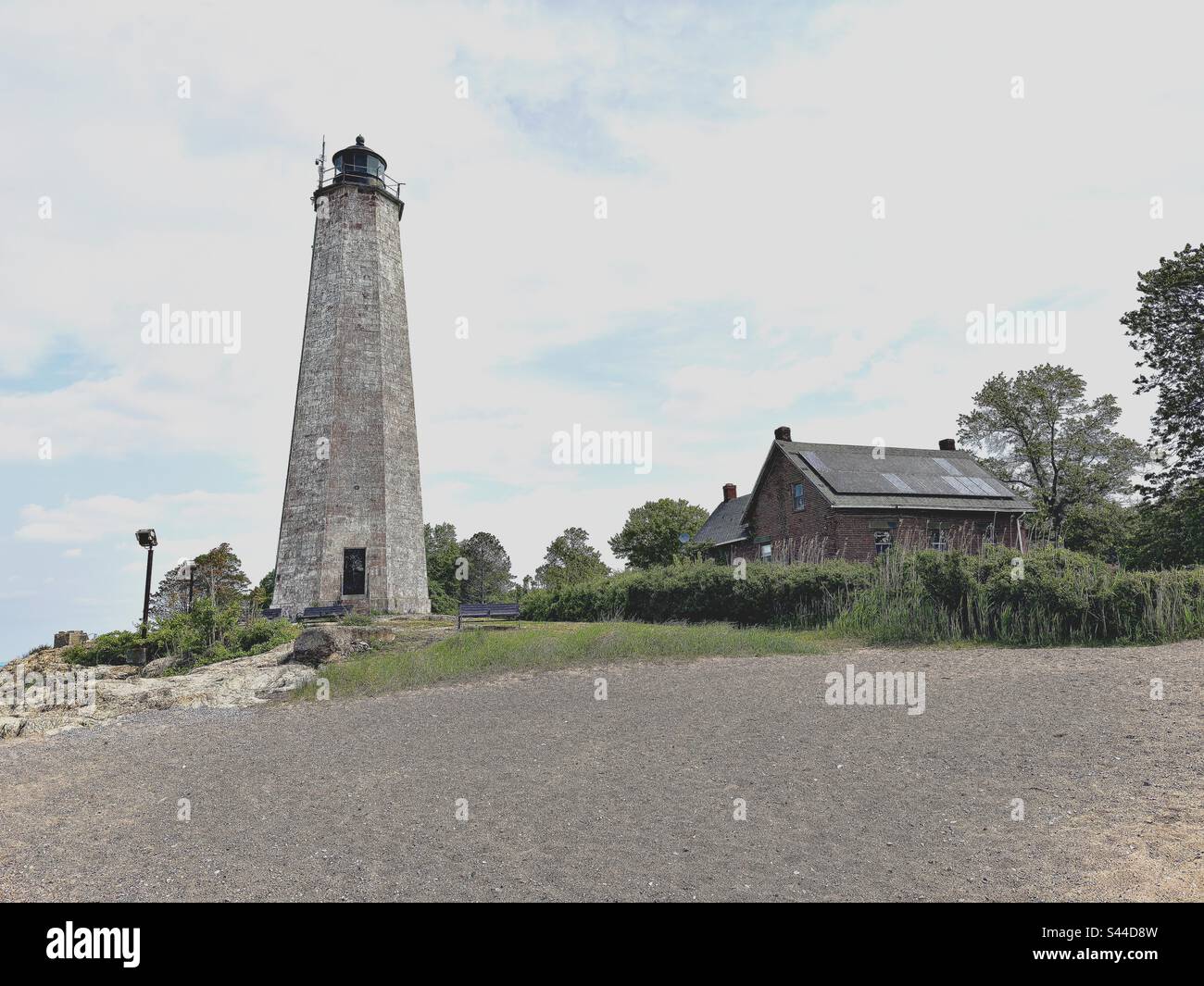 New Haven, Connecticut, USA: Leuchtturm und rotes Haus im Lighthouse Point Park mit kleinem Strandbereich. Stockfoto