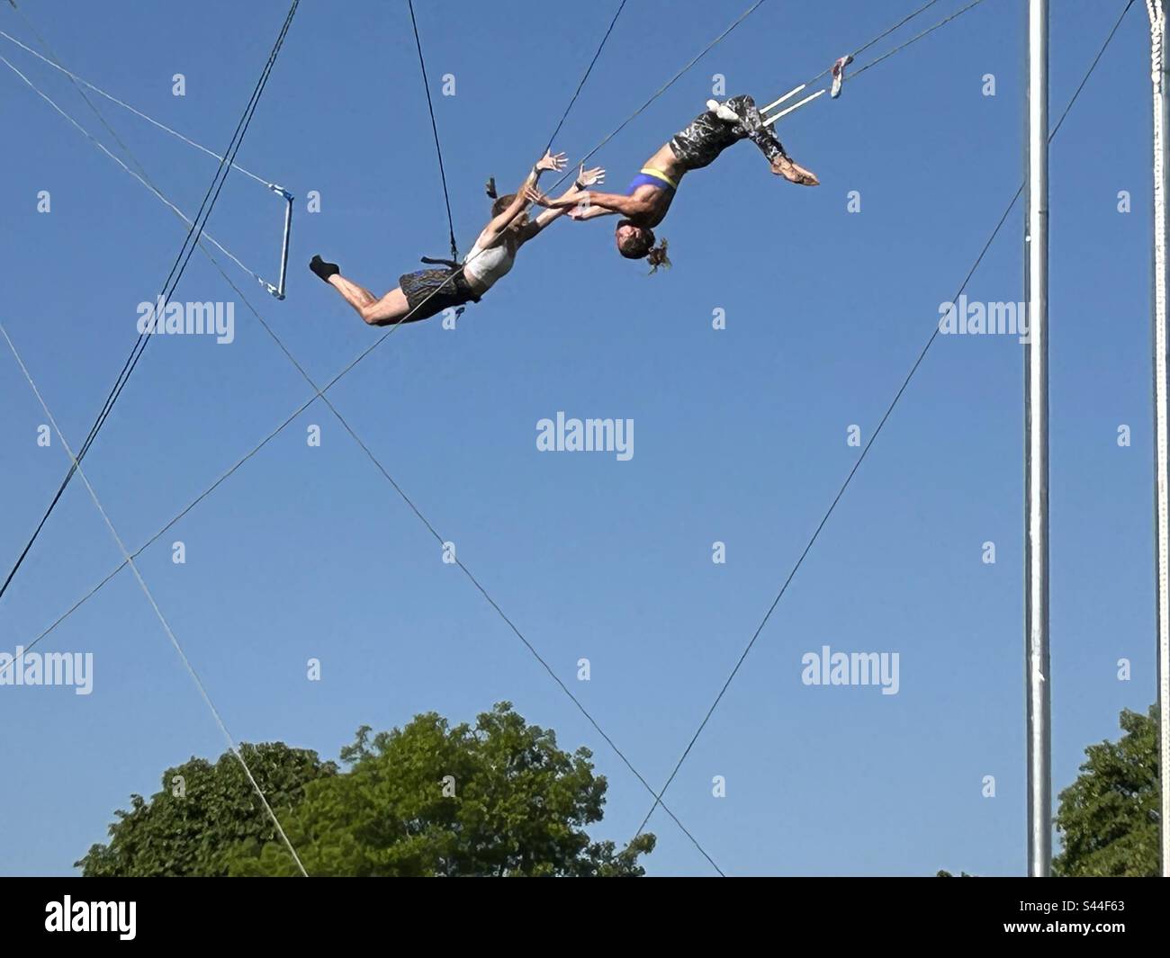 Trapez - 2 Frauen, die sich draußen im Park in der Luft fangen Stockfoto