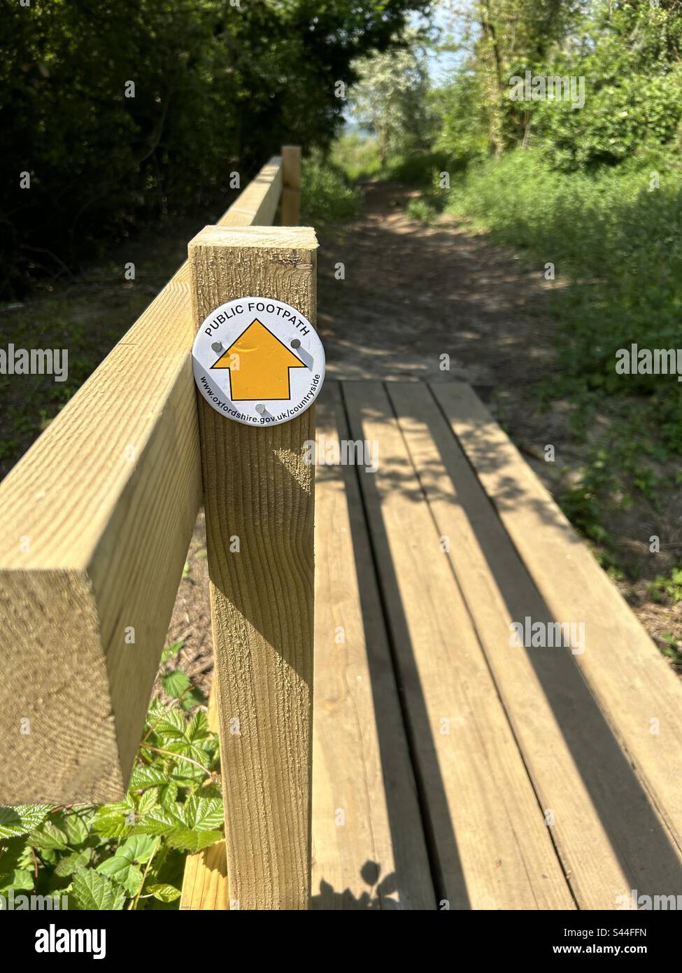 Lye Valley Oxford, öffentlicher Fußweg führt Sie entlang einer hölzernen Brücke über einen Bach - Smartphone-aufgenommenes Stockfoto