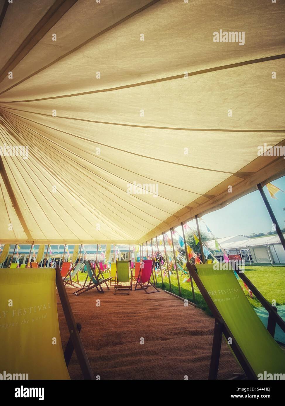 Ein Foto in einem Zelt beim Hay Festival. Liegestühle, Jurten und Leute, die die Sonne genießen Stockfoto