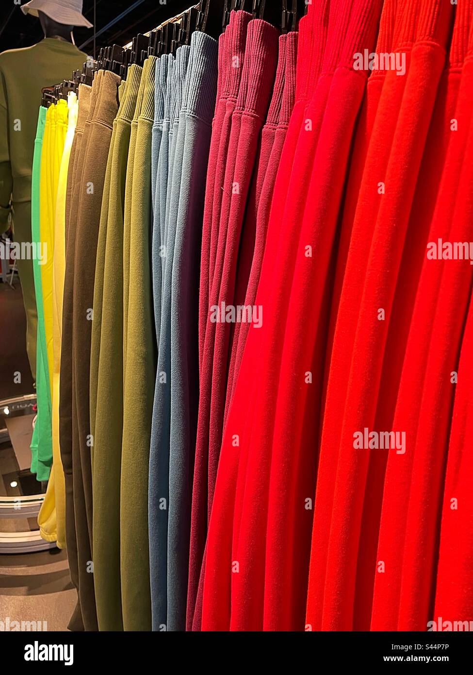 Bunte Jogginghosen hängen im Nike Flagship Store auf der Fifth Avenue, 2023, New York City, USA - Smartphone-aufgenommenes Stockfoto