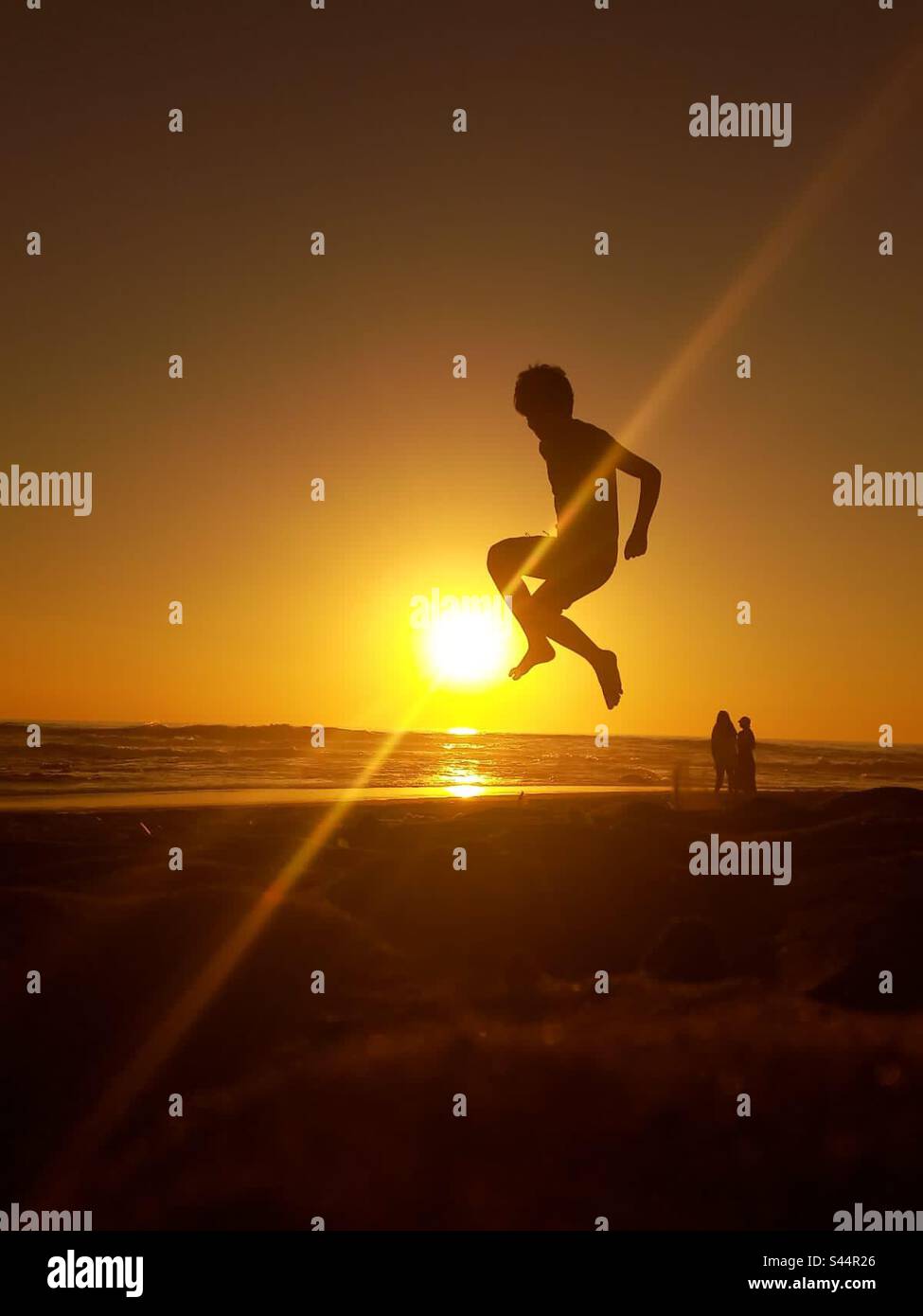 Jugando con el sol, en la playa Stockfoto