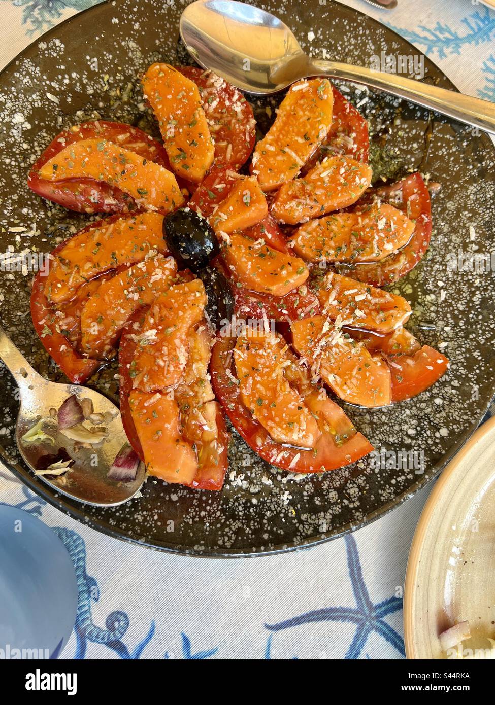 Papaya- und Tomatensalat im spanischen Restaurant. - Smartphone-aufgenommenes Stockfoto