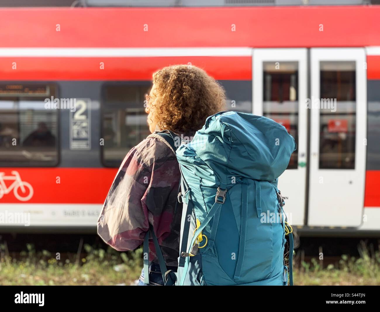 Reisen Sie mit einem riesigen touristischen Rucksack mit dem Zug Stockfoto