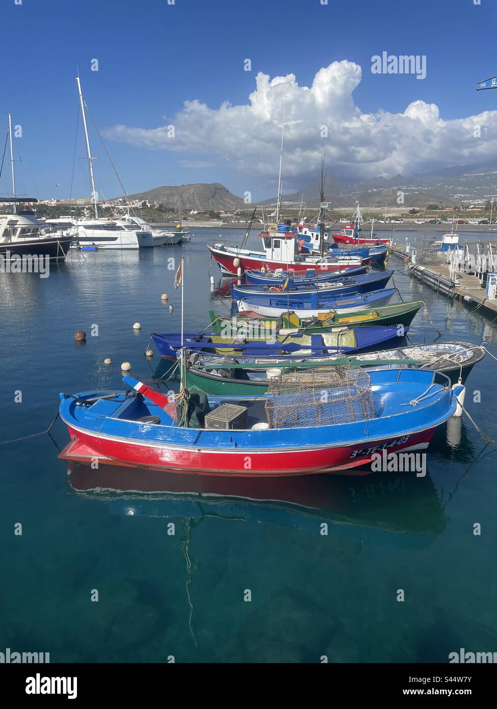 An einem sonnigen Tag auf Teneriffa, Kanarische Inseln, legen verschiedene farbenfrohe Boote an der Marina Del Sur an Stockfoto