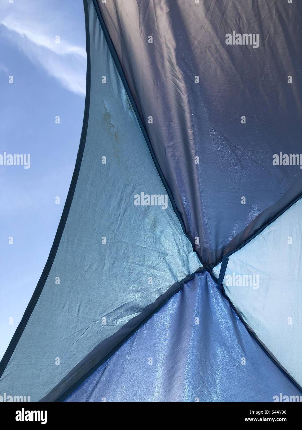 In einem blauen Strandzelt mit Blick auf den blauen Himmel mit weicher Wolke. Stockfoto