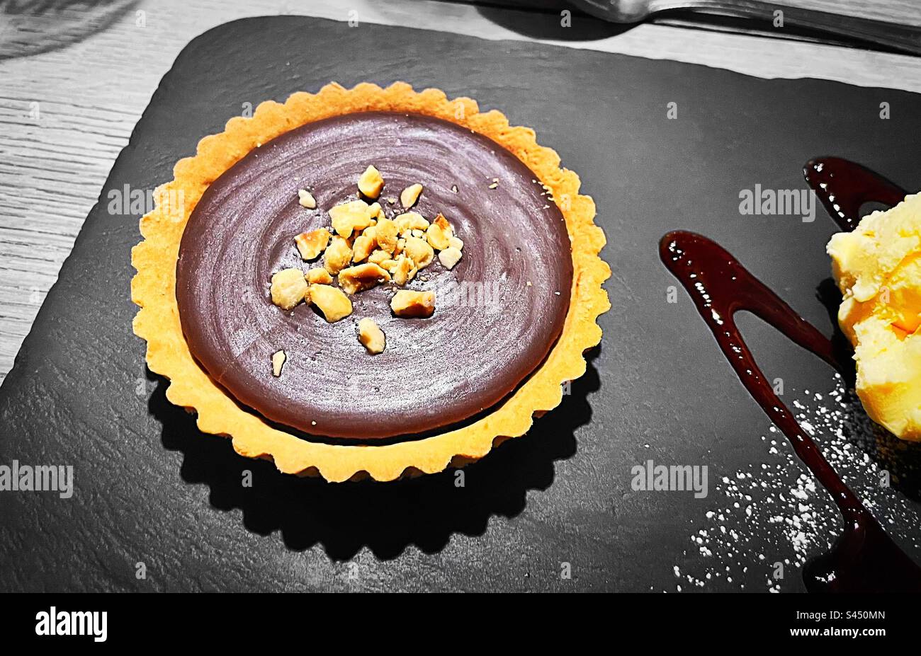 „Desert Dream“ Schokolade und Hazlenut Tart mit Vanilleeis und Himbeercoulis. Stockfoto