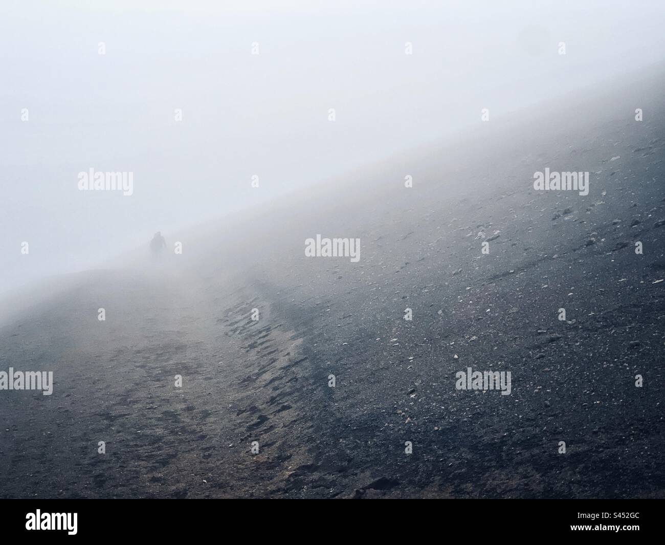 Sie steigen hinab in den Haleakalā, oder den Vulkan East Maui, Krater in den Wolken Stockfoto