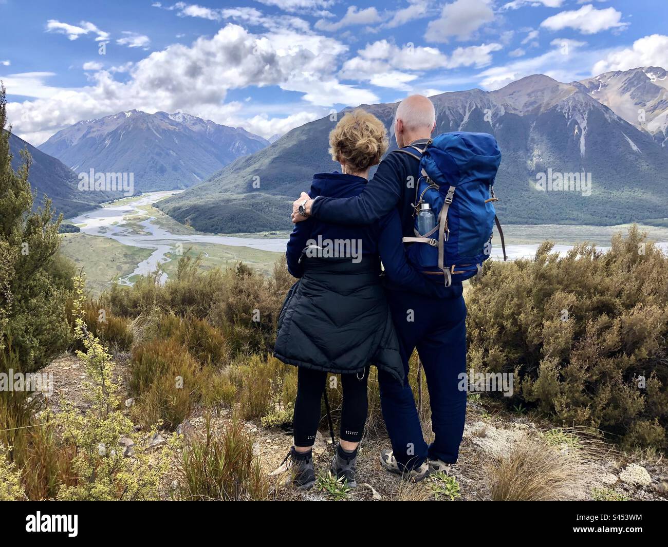 Ein älteres Paar blickt über die Berge, während es auf dem Bealey Spur Track wandert. Stockfoto