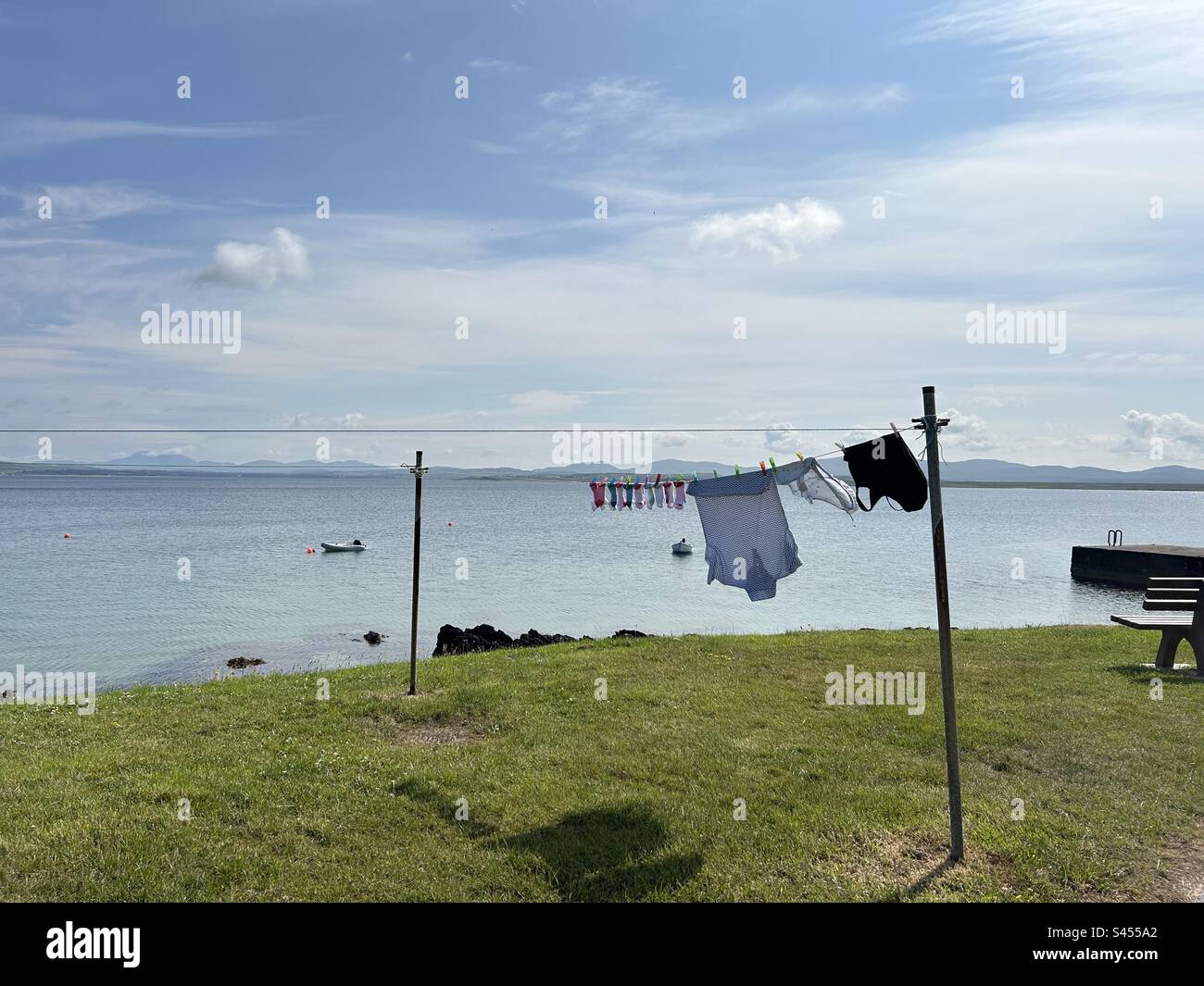 Wäscheleine mit im Wind wehenden Kleidern auf der Insel Islay, Schottland - Smartphone-aufgenommenes Stockfoto