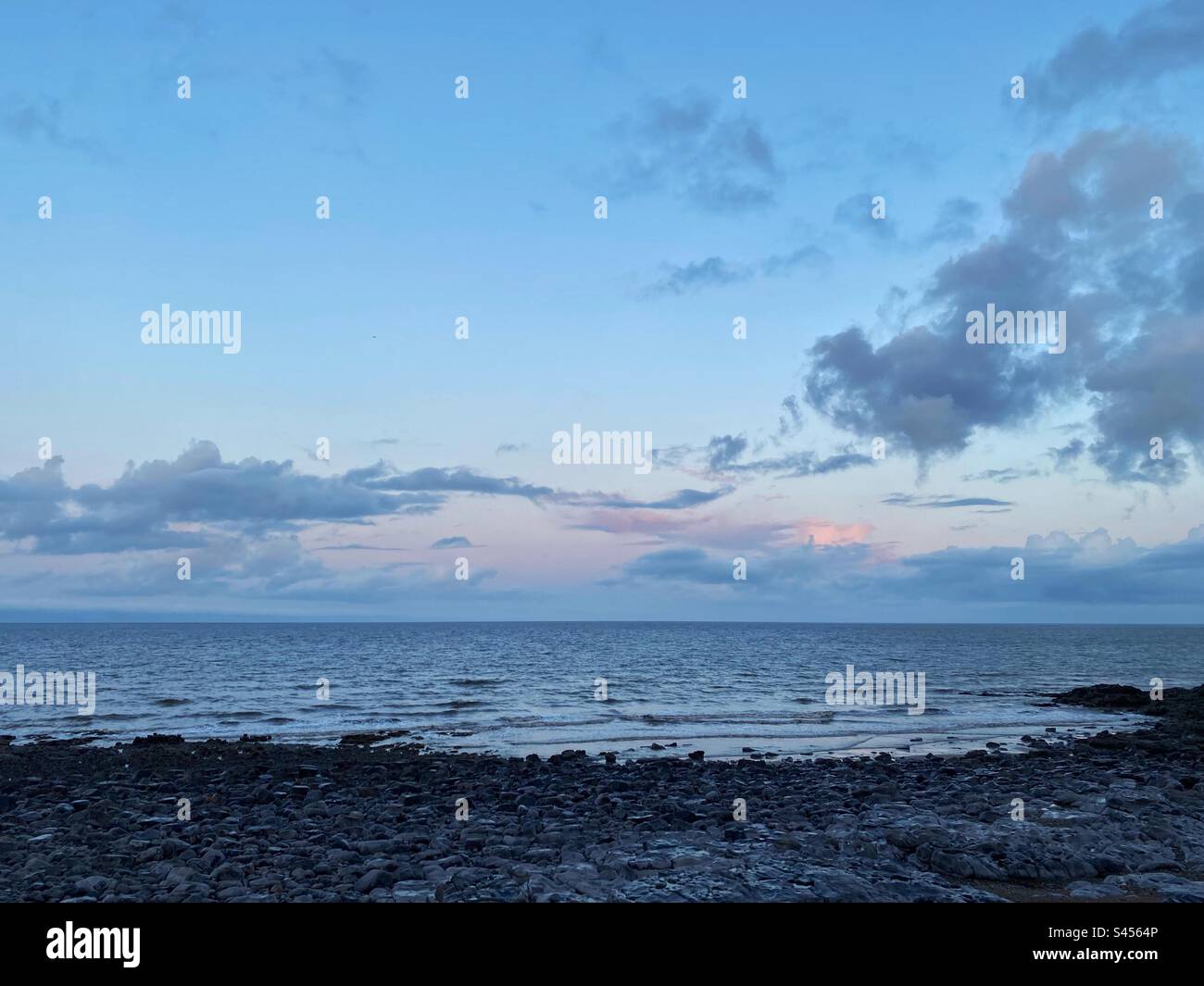 Ein Foto eines Sonnenaufgangs am Strand an der Jurassic Coast in Ogmore, Südwales Stockfoto