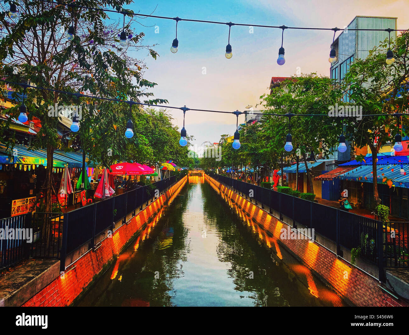 Der Kanal ong Ang in Bangkok, Thailand, bietet einen Blick auf den Kanal in der Abenddämmerung mit Nachtmarktern Stockfoto