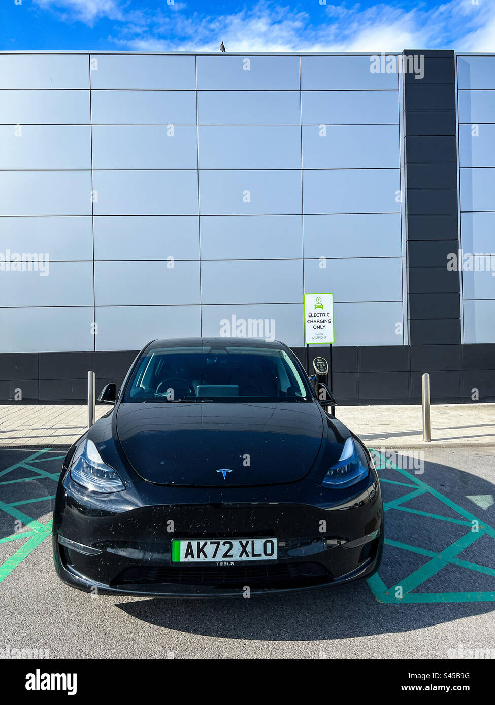 Aufladen des schwarzen Tesla Model Y Elektrofahrzeugs Stockfoto