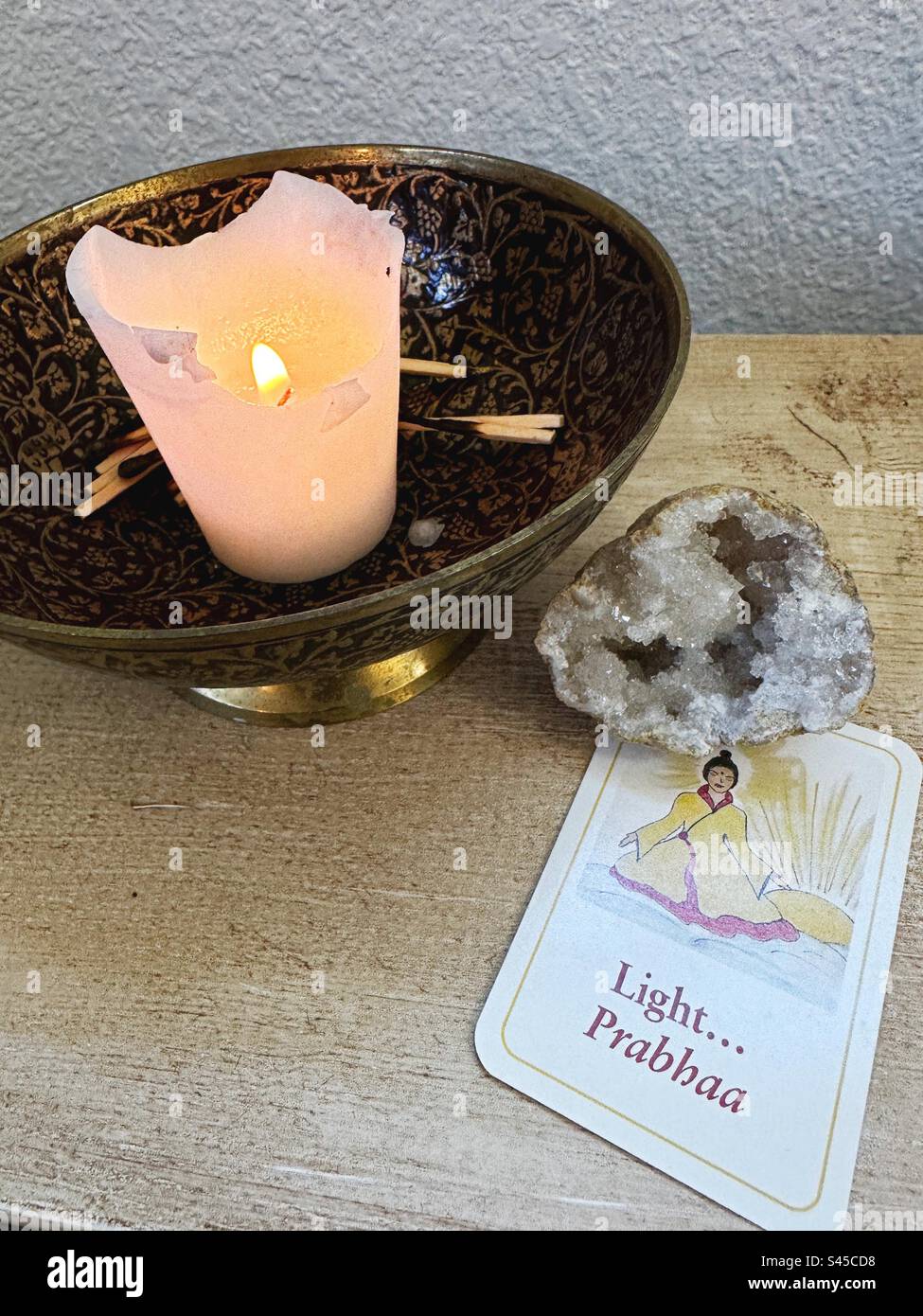 Eine Kerze neben einer Meditationskarte mit dem Wort "Licht". Stockfoto