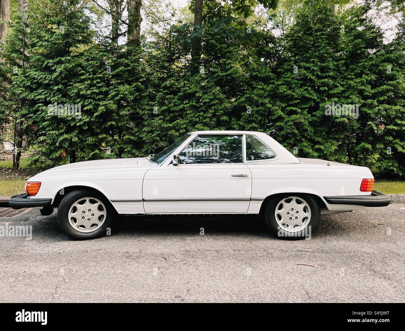 Ein klassischer alter weißer Mercedes Benz, der in einer Vorstadtstraße in New Jersey, USA, geparkt hat. - Smartphone-aufgenommenes Stockfoto