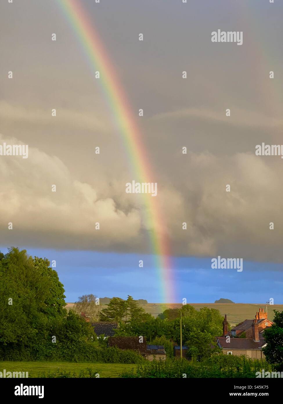 Mehrfarbiger Regenbogen vor den Cumuluswolken über dem Tal von Pewsey Wiltshire England - Smartphone-aufgenommenes Stockfoto
