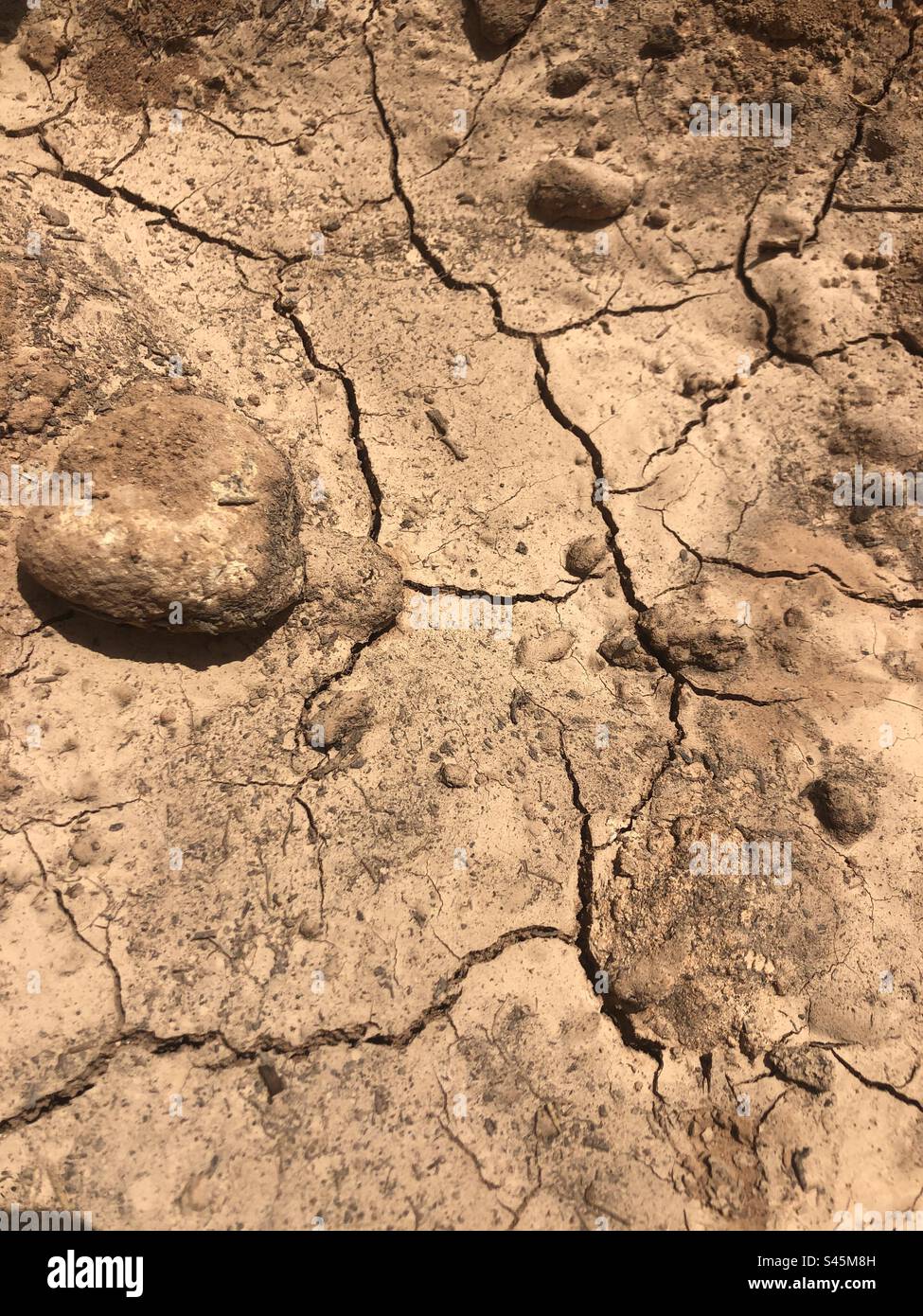 Bild einer zerbrochenen Erde, die während der Hitzewelle in Spanien, Südeuropa, die Dürre im Juli 2023 verursachte, aufgenommen wurde - Smartphone-aufgenommenes Stockfoto