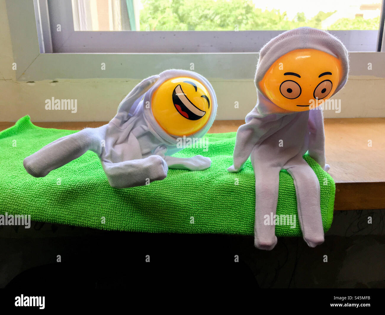 Eine Puppe mobbt die andere Puppe. Darstellung einer Mobbing-Situation mit Puppen mit Emoticon-Gesichtern. Stockfoto