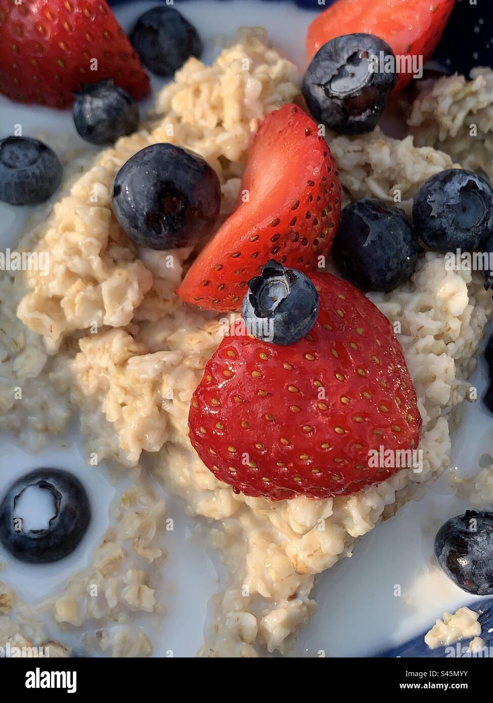 Haferflocken mit Milch und frischen Beeren Stockfoto