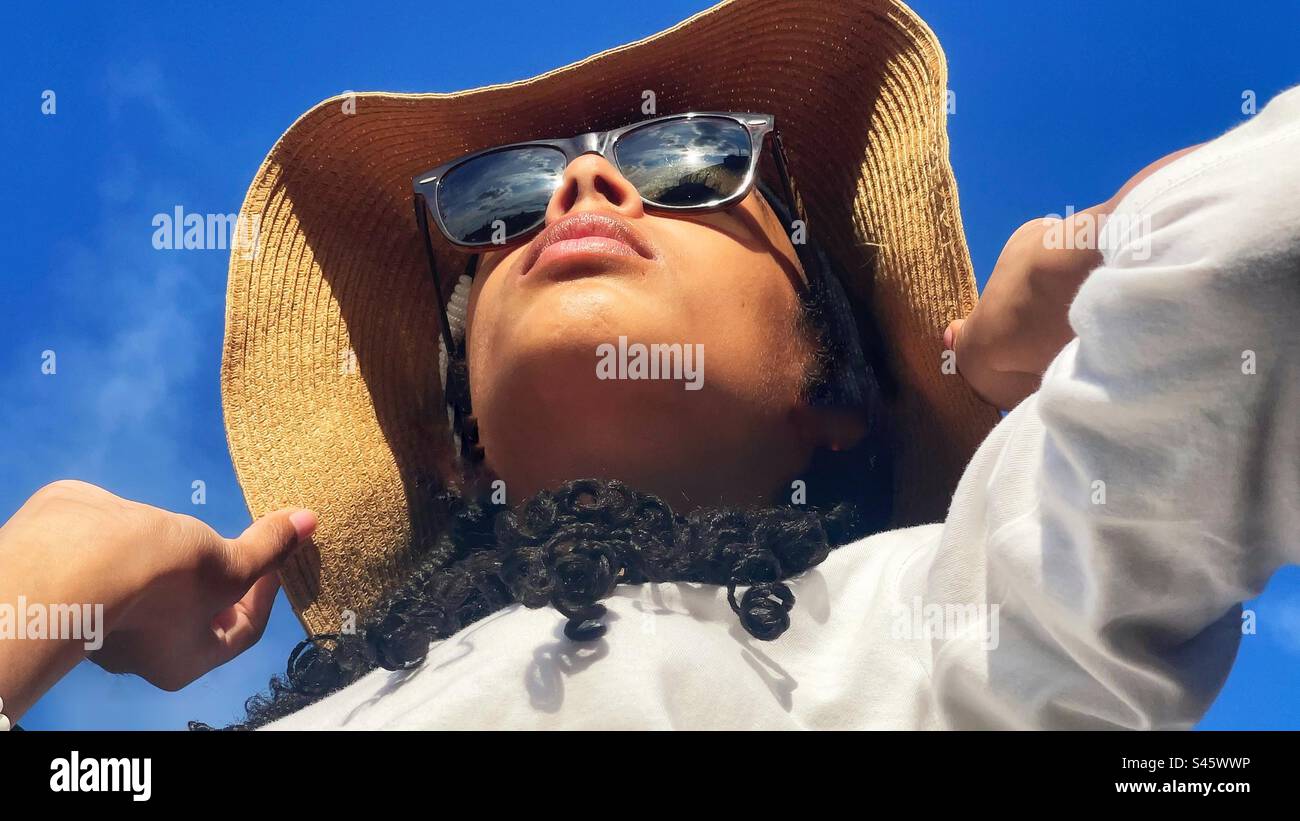 Ein Mädchen mit einem Floppy-Hut - Smartphone-aufgenommenes Stockfoto