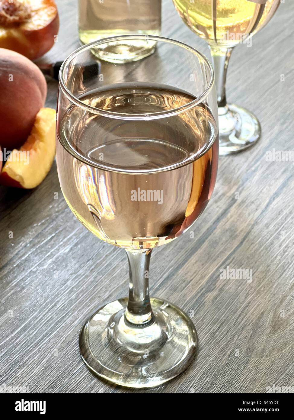 Ein Glas Pfirsichwein auf einem Holztisch Stockfoto