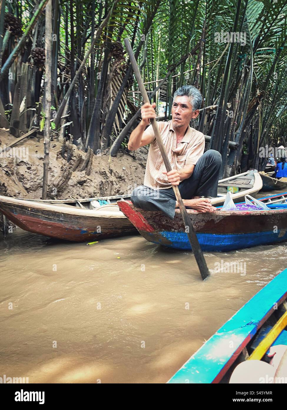 Ein vietnamesischer Mann rudert sein Boot. Mekong Delta River Tour, Vietnam. Stockfoto