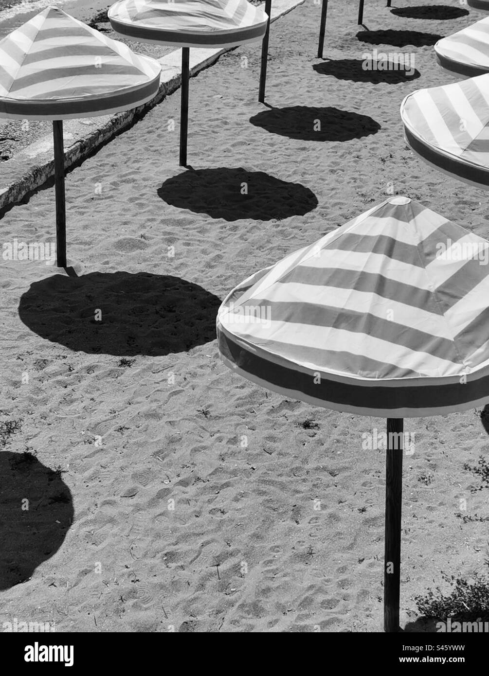 Strandschirme und deren Schatten schwarz-weiß Stockfoto