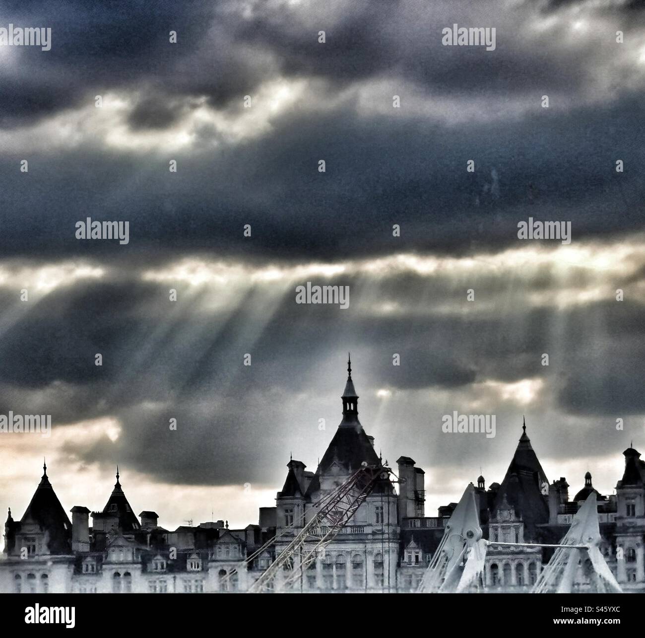 Dramatische Skyline der Stadt mit Wolken und Sonnenstrahlen Stockfoto