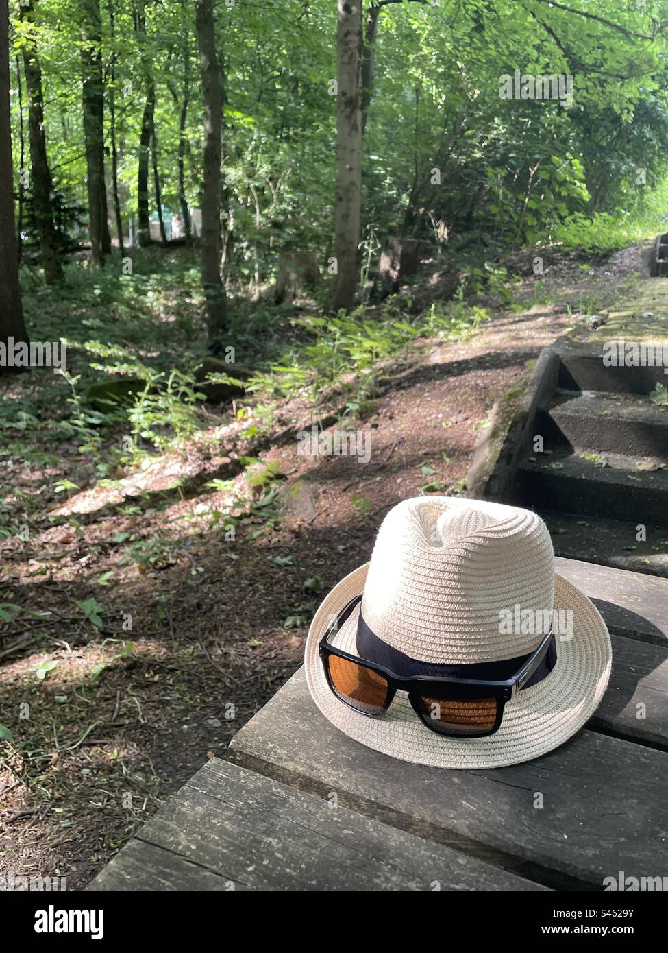 Hut und Sonnenhandschuhe während einer Pause - Smartphone-aufgenommenes Stockfoto