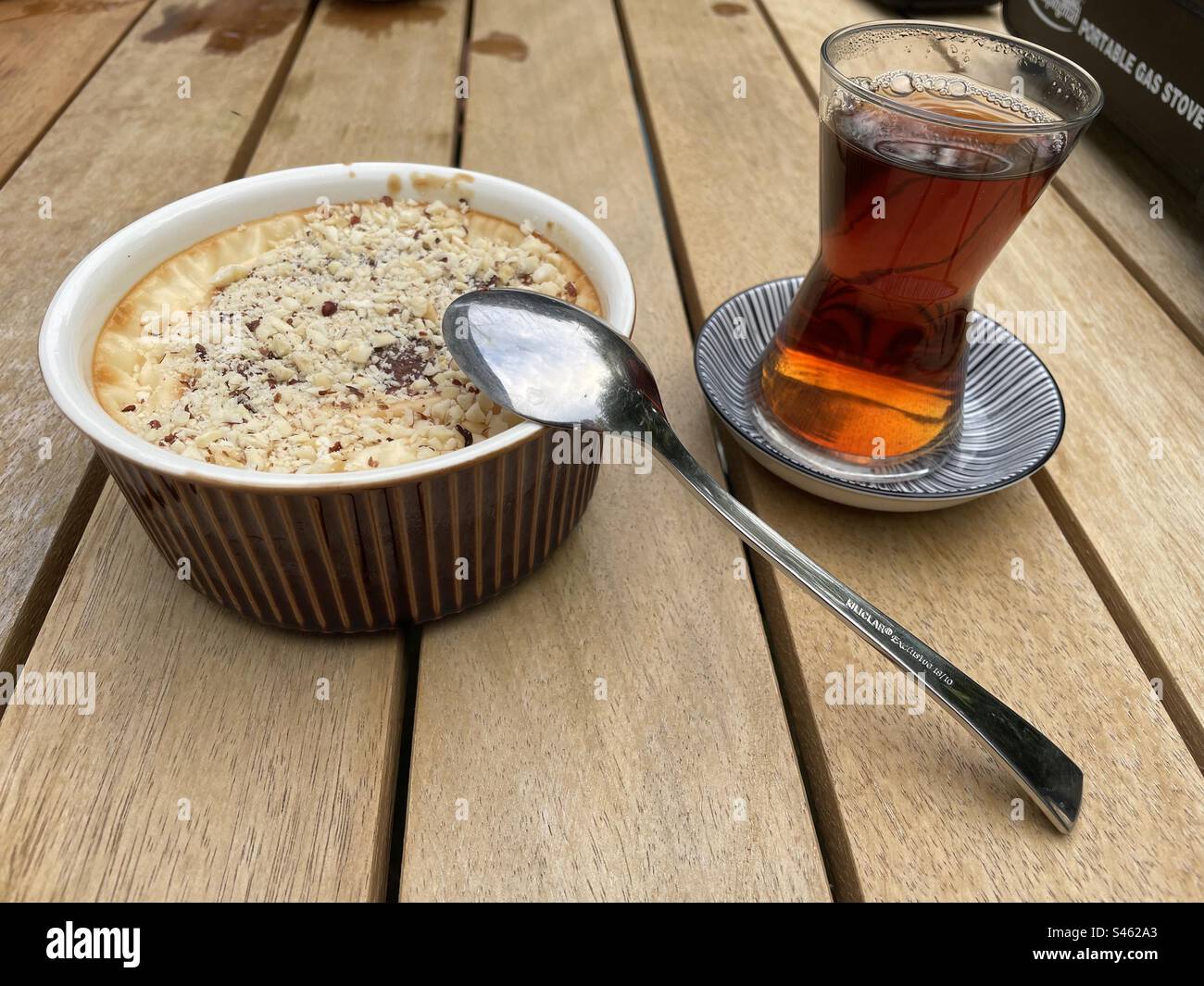 Tee am Ende der Arbeit mit Nachtisch - Smartphone-aufgenommenes Stockfoto