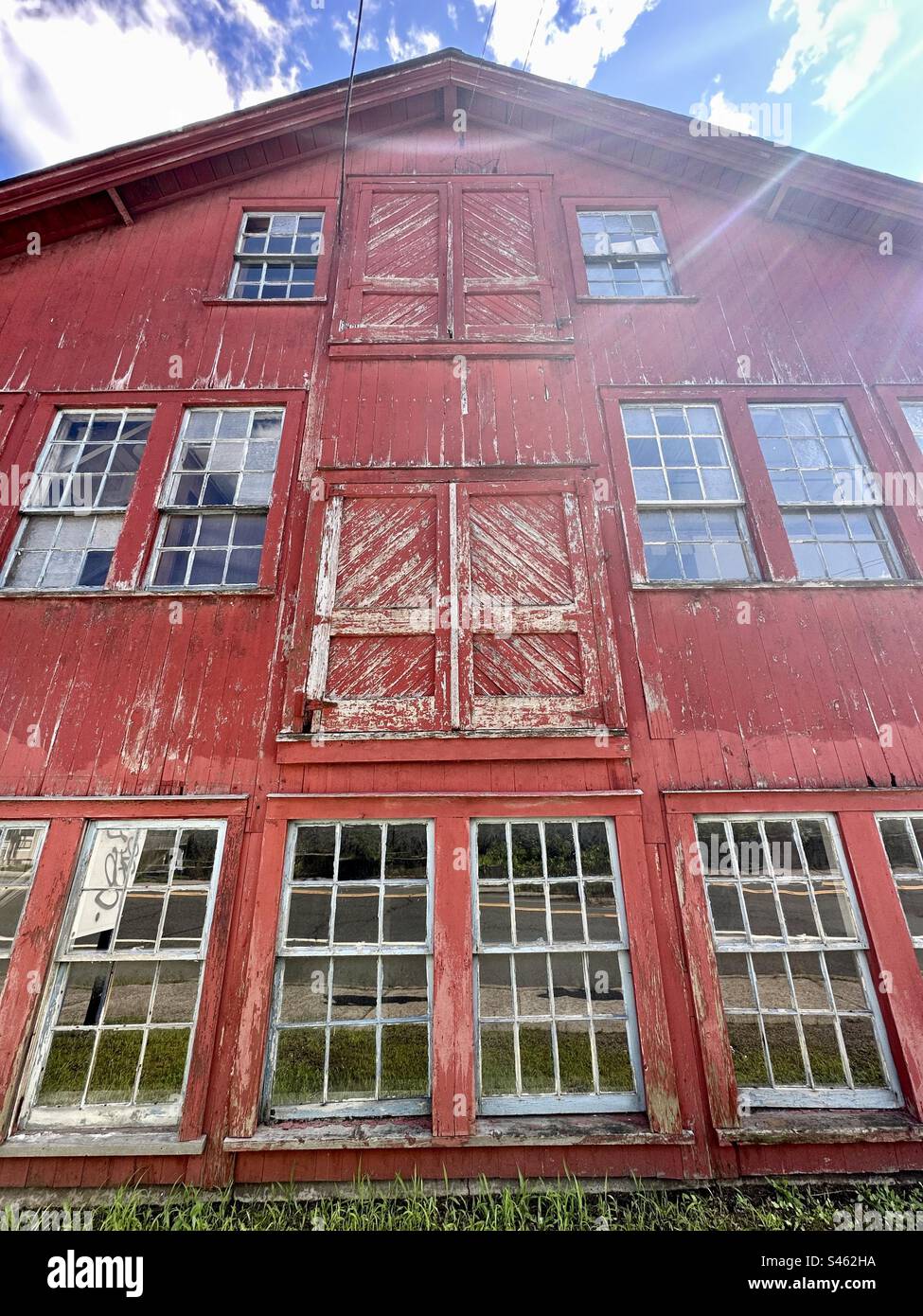 Alte rote Scheune in Collinsville, Connecticut, USA, mit Sonnenschein. Oldtimer-Gebäude im historischen Viertel. - Smartphone-aufgenommenes Stockfoto