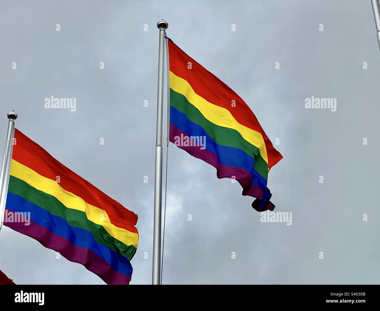 LBGT-Flagge vor bewölktem Himmel Stockfoto