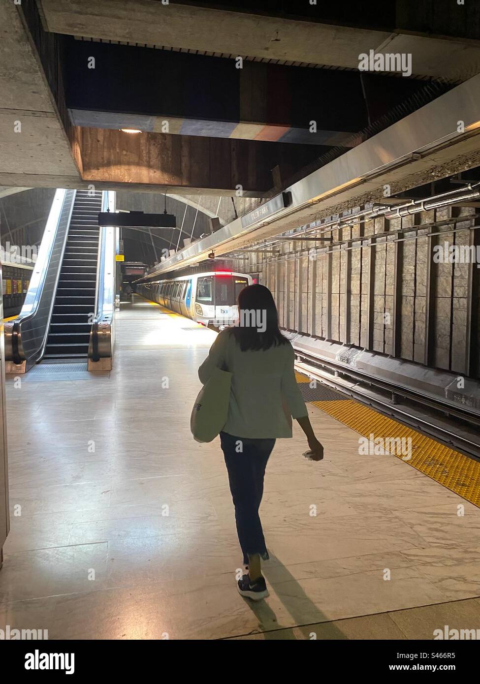 Unbekannte Frau auf dem Bahnsteig der Glen Park BART-Station in San Francisco, während der Zug aus der Station fährt Stockfoto