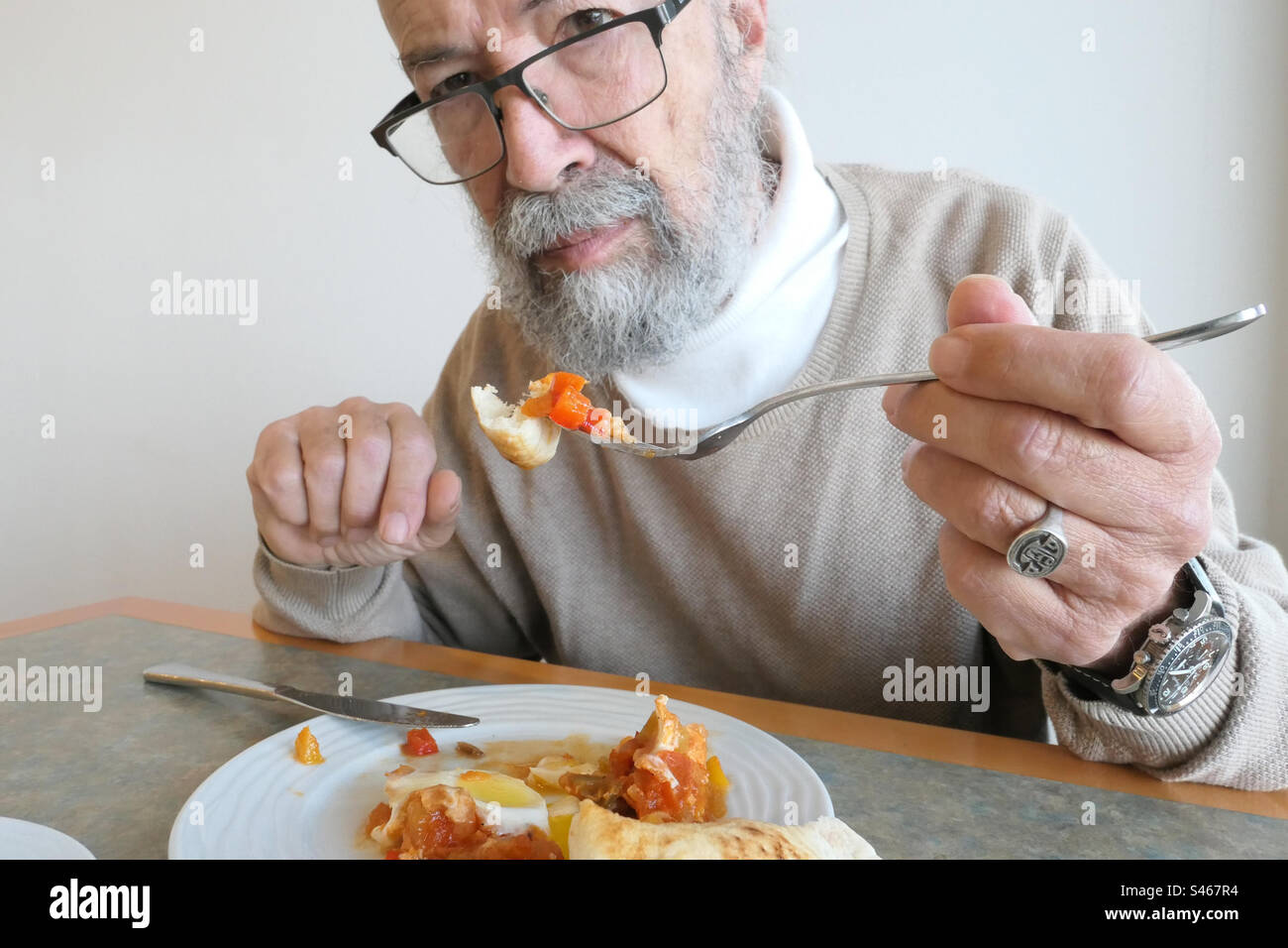 Seniorenmann isst zu Hause Stockfoto