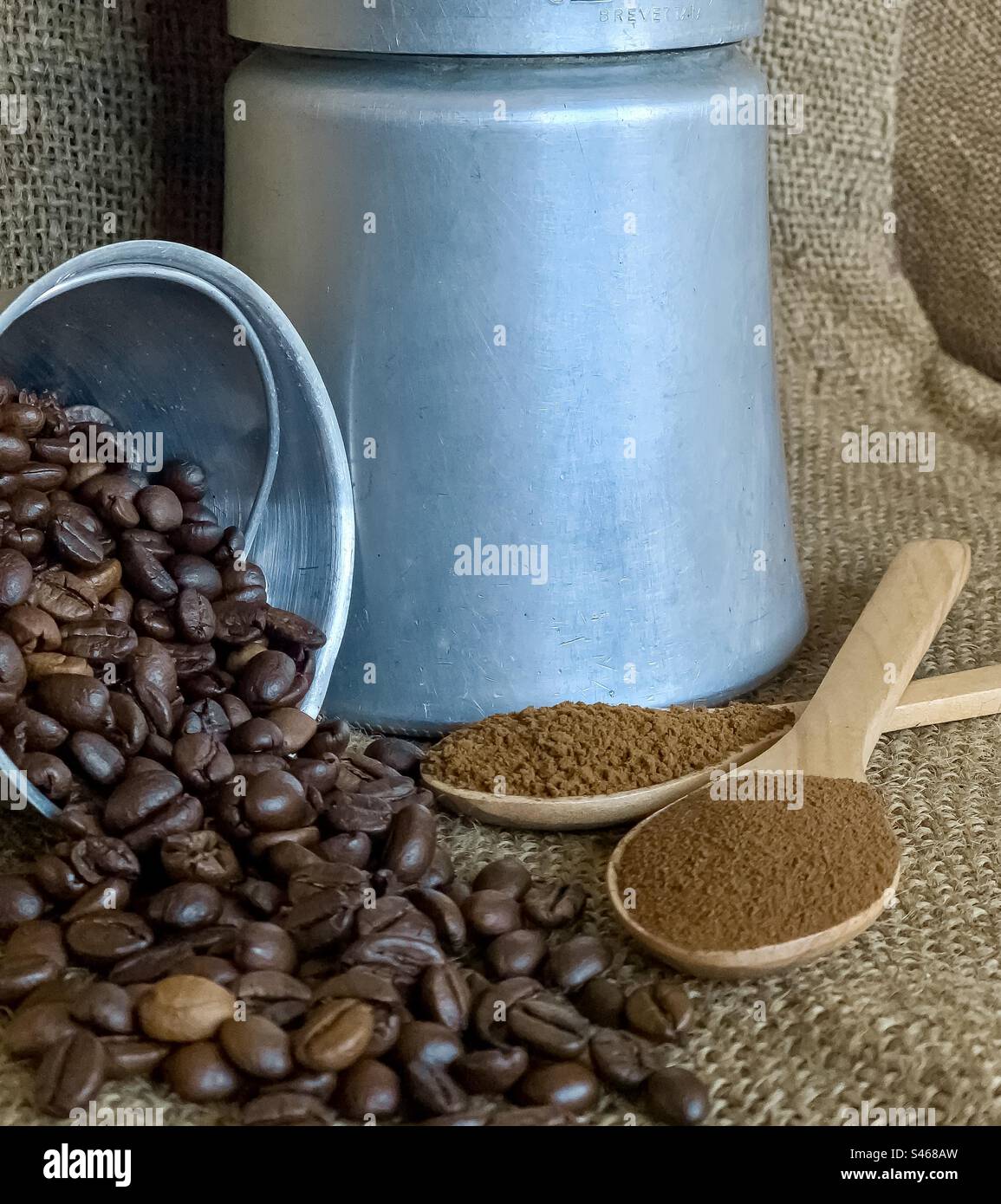 Kaffeebohnen und gemahlener Kaffee mit Herdplatten-Cafeteria auf Sacktuch - Smartphone-aufgenommenes Stockfoto