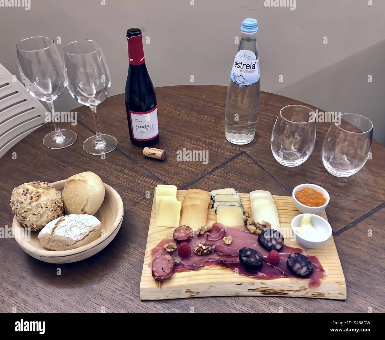 Eine Auswahl an Aufschnitt, Käse und Brot, serviert mit Wasser und Rotwein - Smartphone-aufgenommenes Stockfoto