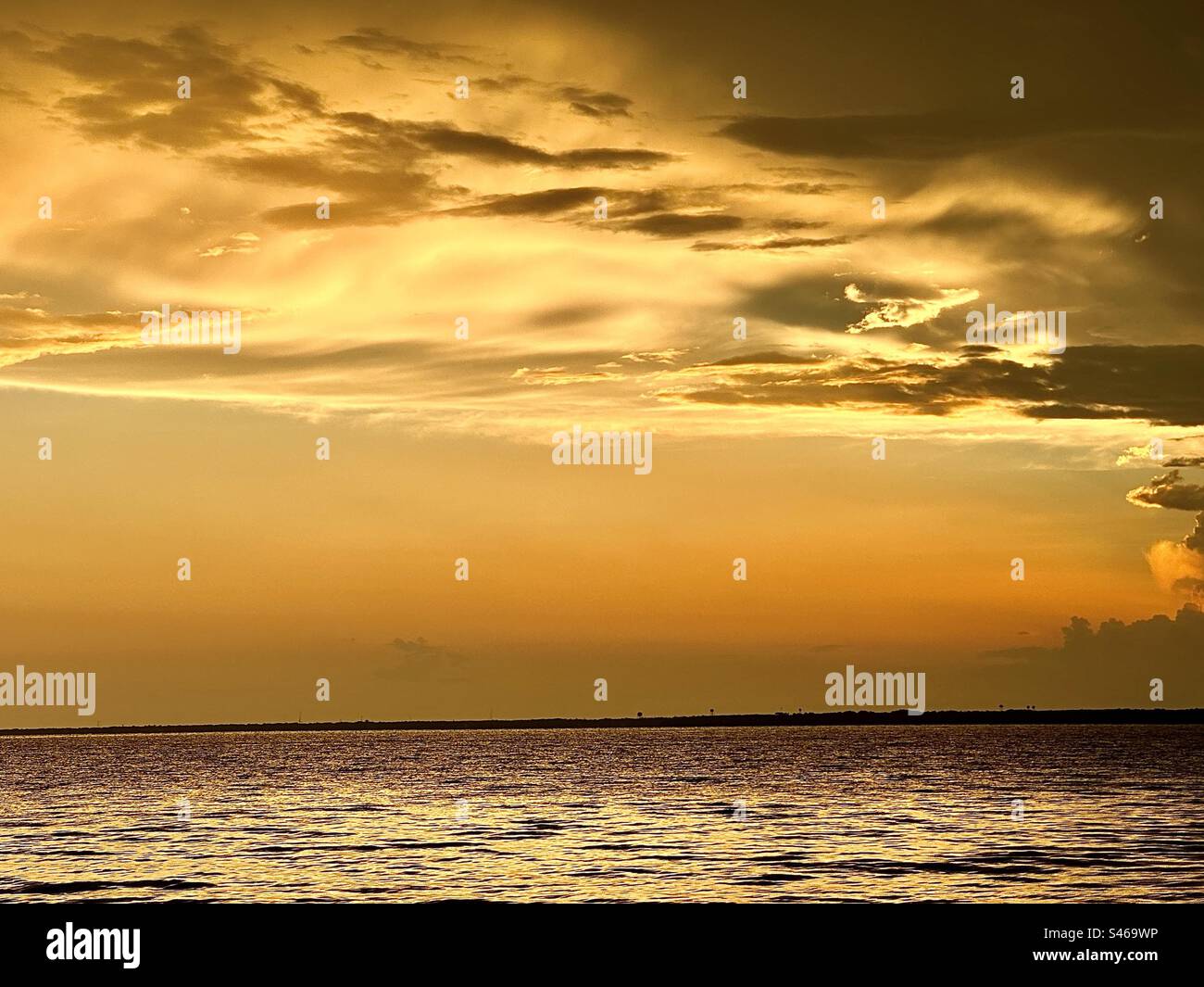 Ungewöhnliche Wolkenbildung bei Sonnenuntergang nach einem Bürgermeister, stürmisches Wetter, Blick auf Bäume in der Ferne. Stockfoto