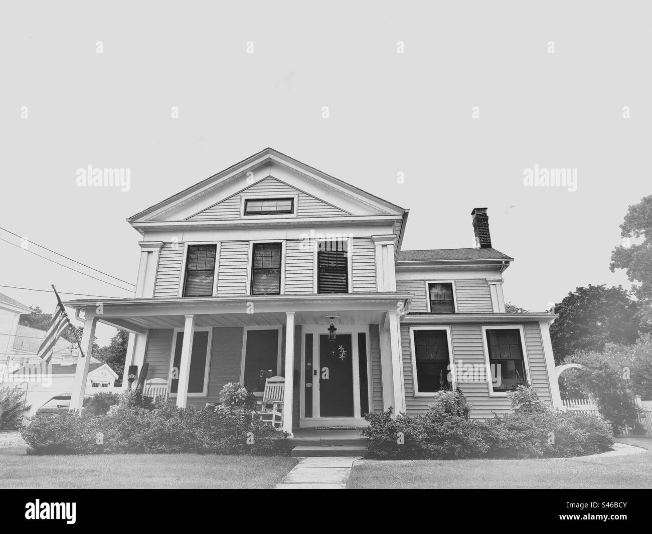 Schwarz-weiß-Filter eines alten, alten Hauses in Clinton, Connecticut, USA. Das Haus hat eine große Veranda und befindet sich im historischen Viertel der kleinen Stadt New England. - Smartphone-aufgenommenes Stockfoto