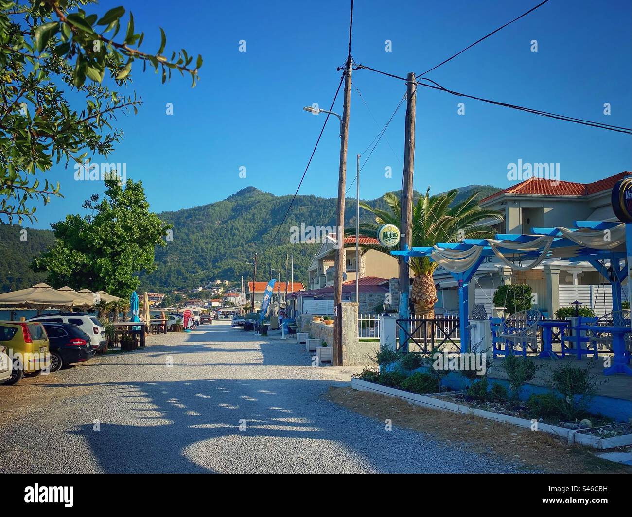 Blick auf die Straße mit grünem Hügel im Hintergrund im Skala Potamias Seaside Resort auf der Insel Thassos, Griechenland. Stockfoto