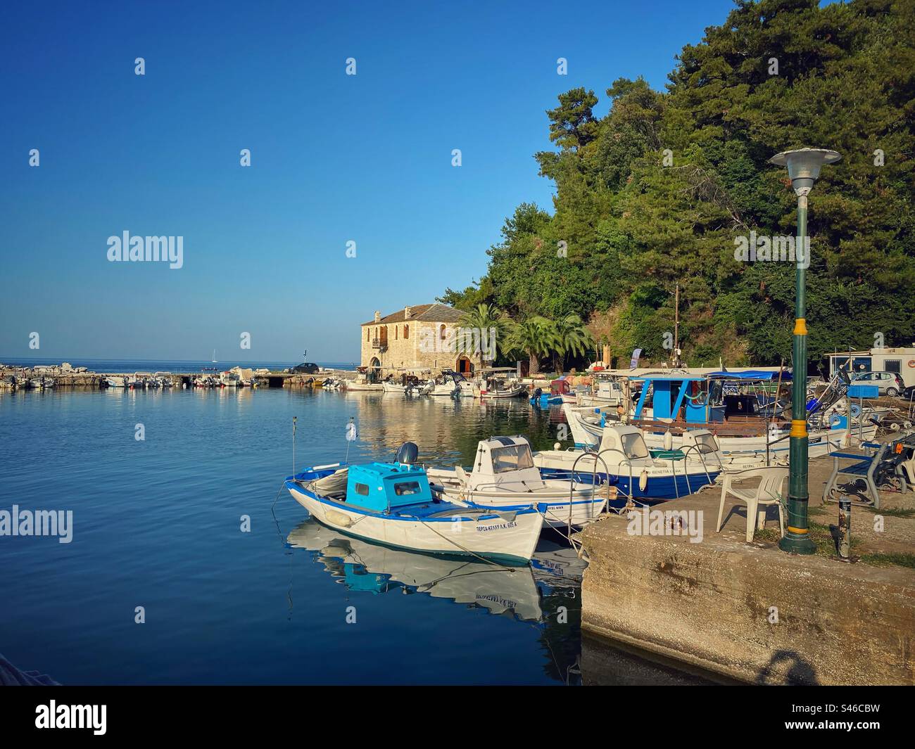 Alter Hafen mit Booten bei Sonnenuntergang in Skala Potamias auf der Insel Thasos, Griechenland. - Smartphone-aufgenommenes Stockfoto